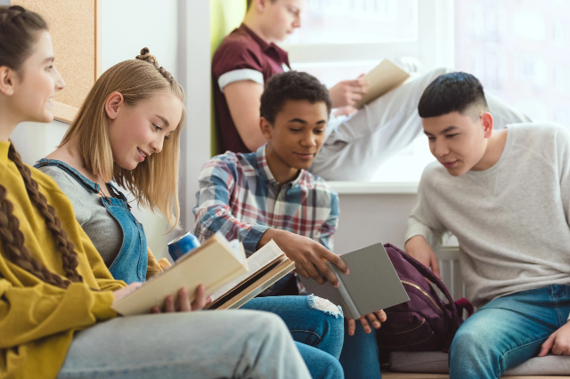 A group of teenage students looking at books